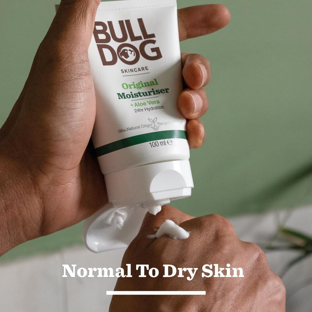 Hand holding a tube of Bulldog Original Moisturiser with a green background